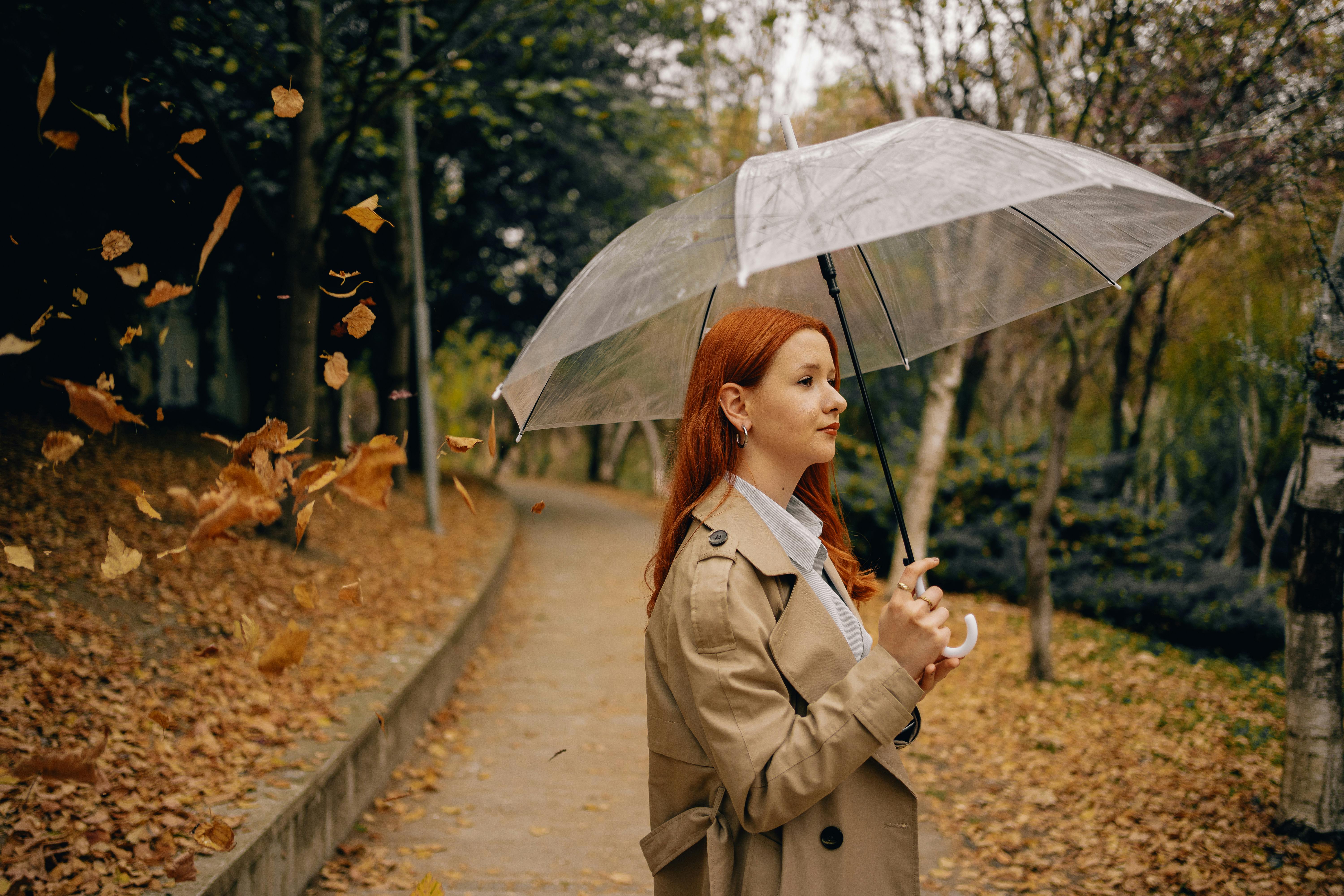 Premium Photo | Woman holding an umbrella posing isolated against the blank  wall