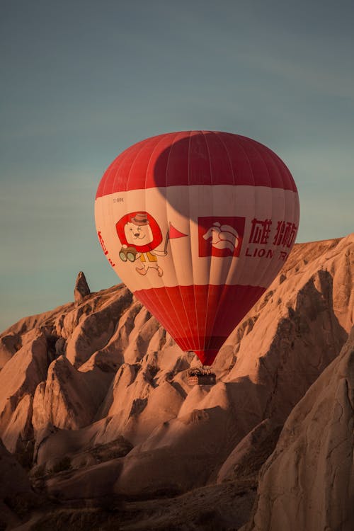 A Hot Air Balloon Flying over Hills at Sunset 