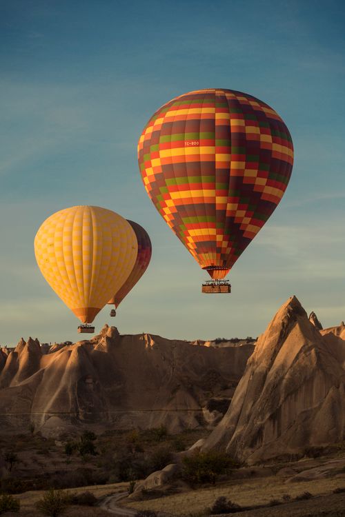 Free Colorful hot air balloons soaring over Cappadocia's unique landscape during sunrise. Stock Photo