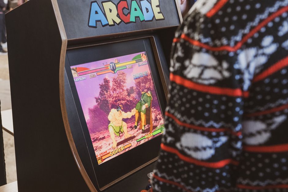 A person in a sweater enjoying a classic arcade game in Zagreb, Hrvatska. A person in a sweater enjoying a classic arcade game in Zagreb, Hrvatska.