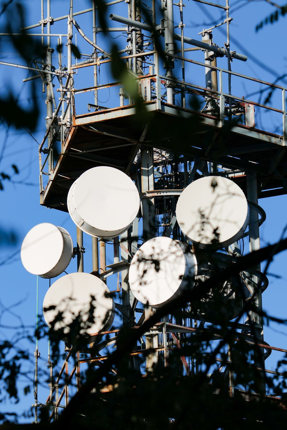 Telecommunication tower with antennas and satellite dishes against a clear sky