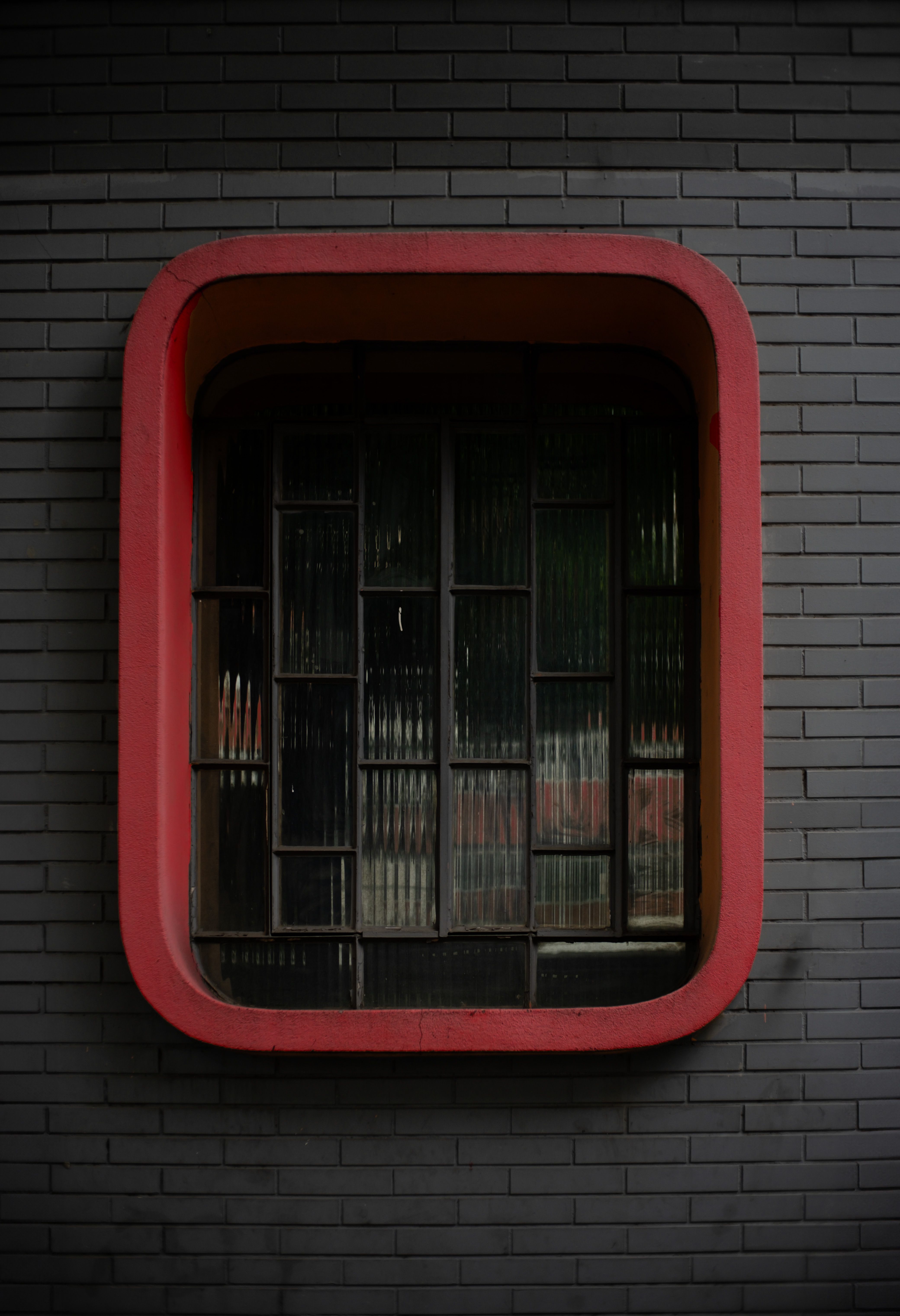 Window in the Rounded Red Frame of a Gray Brick Building · Free Stock Photo