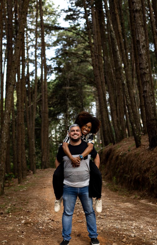 Woman Riding Piggyback on a Man in a Forest
