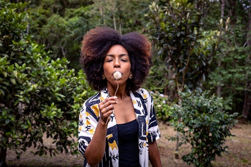 Woman Posing with Dandelion in Hand