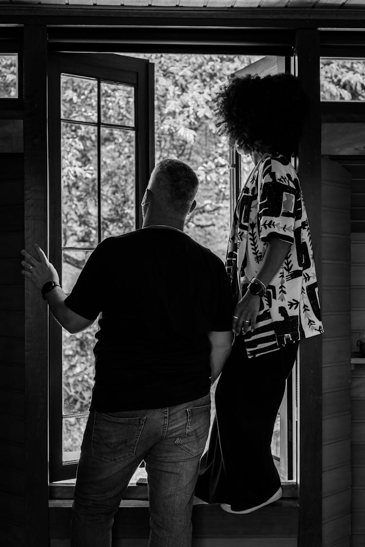 Couple Looking Out The Window In Black And White 