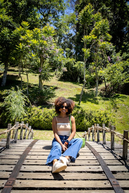 Smimling Woman Sitting on Wooden Footbridge