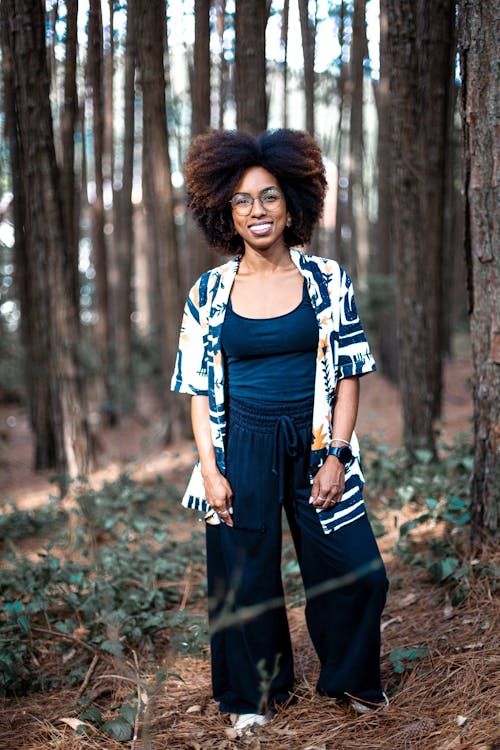 Smiling Woman in a Shirt Standing in a Forest