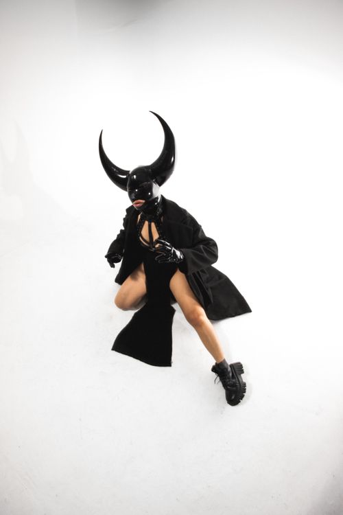 Free A model in a horned mask and costume poses dramatically in a studio setting. Stock Photo