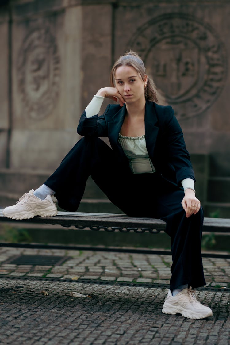 Model In Suit Jacket Sitting On Bench