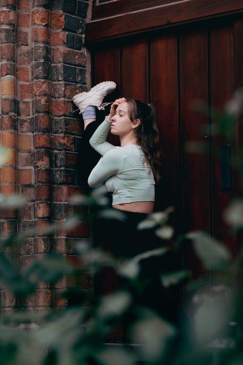 Dancer Stretching by Wooden Gate