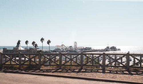 Free A scenic view of Santa Monica Pier with palm trees and Ferris wheel under bright sunlight. Stock Photo