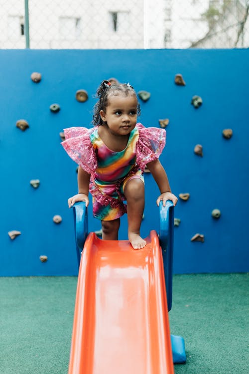 Little Girl at the End of a Slide Stock Photo