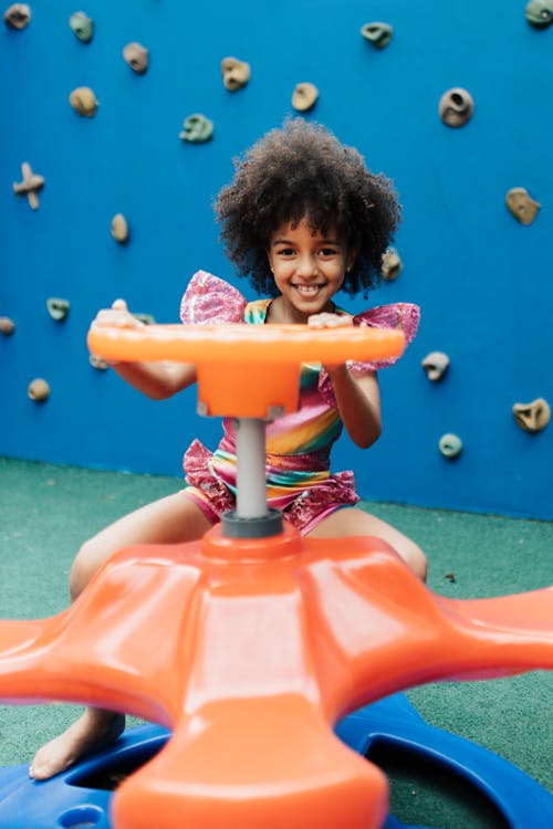 Smiling Little Girl Sitting on Carousel