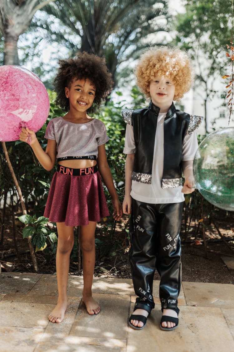 Young Boy And Girl Holding Balloons