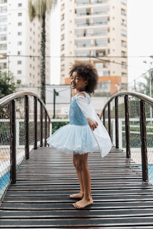 Little Girl Wearing Dress on a Wooden Bridge in a Tropical Resort 