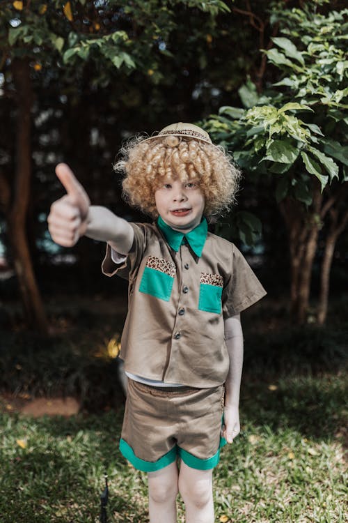 A Little Boy Standing Outside and Showing Thumbs Up 