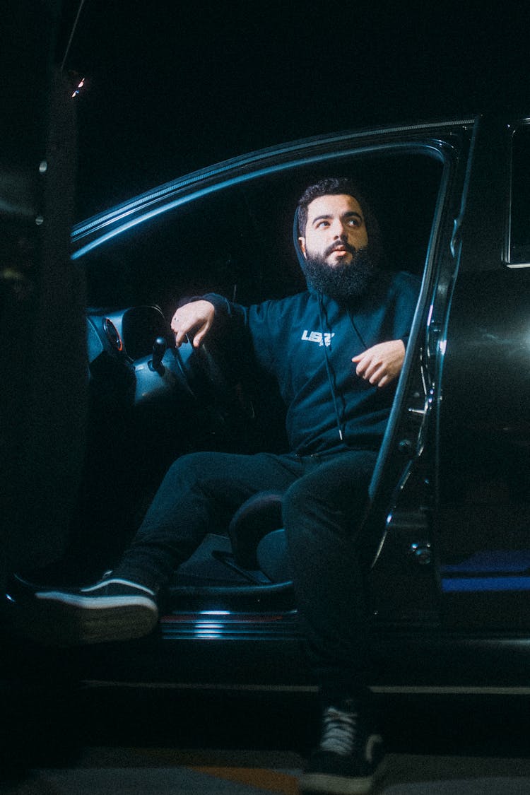 Man Sitting In A Black Car 