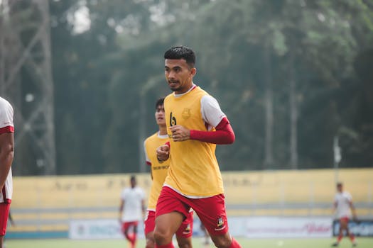 Dynamic shot of a football player in mid-game at an outdoor field, showcasing determination and focus.