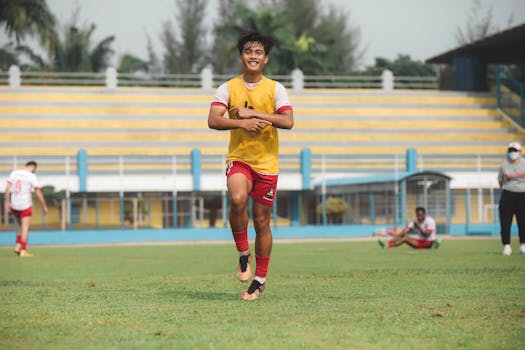 A young athlete in action, partaking in football practice at a Jakarta soccer field.