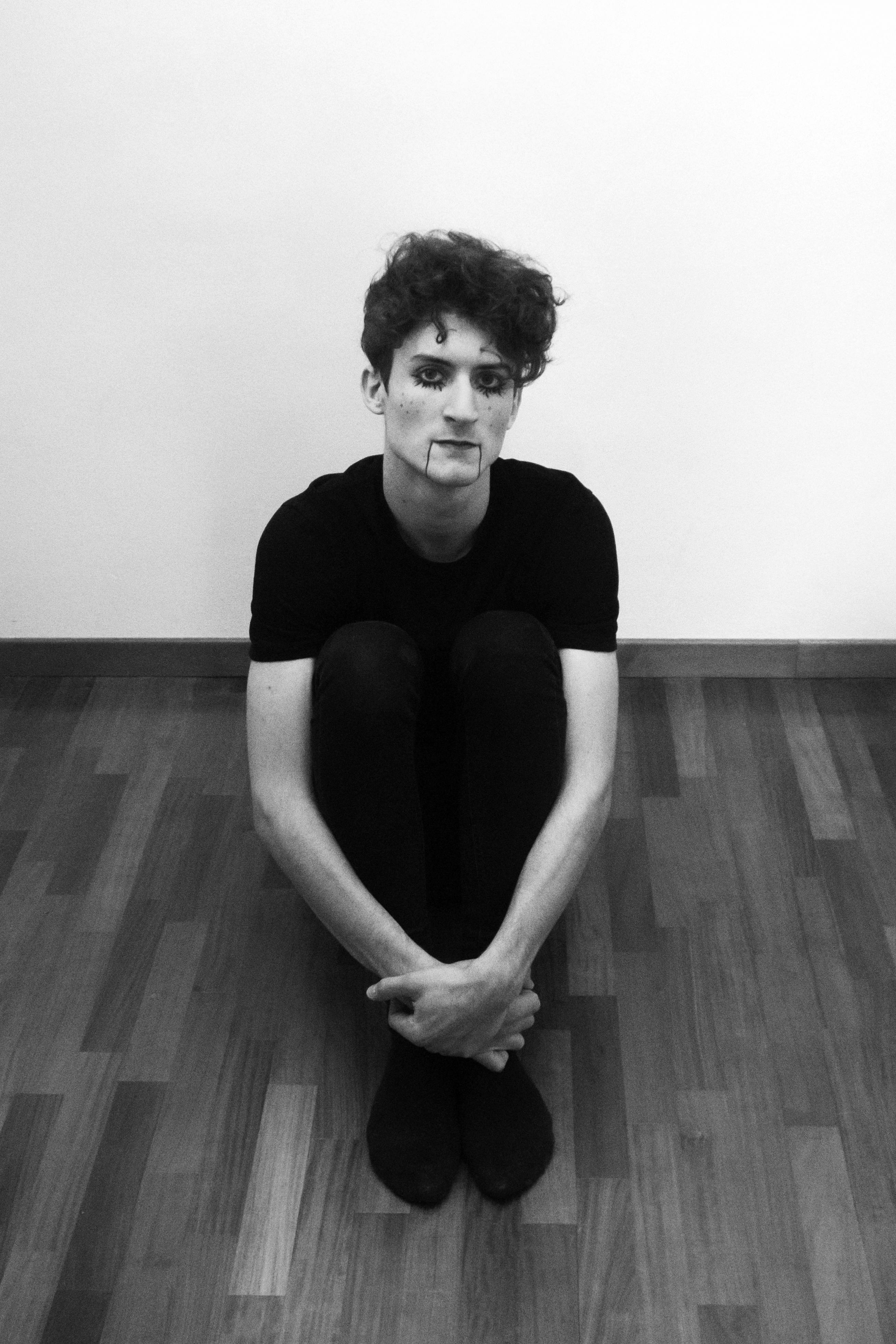 Grayscale Photo of Man Sitting on Floor