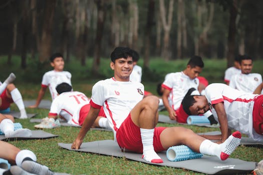 Soccer team members stretching outdoors in Jakarta, Indonesia