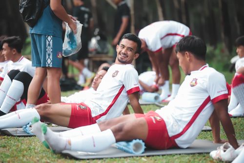 Free Soccer players in Jakarta relaxing on mats during a practice session outdoors. Stock Photo