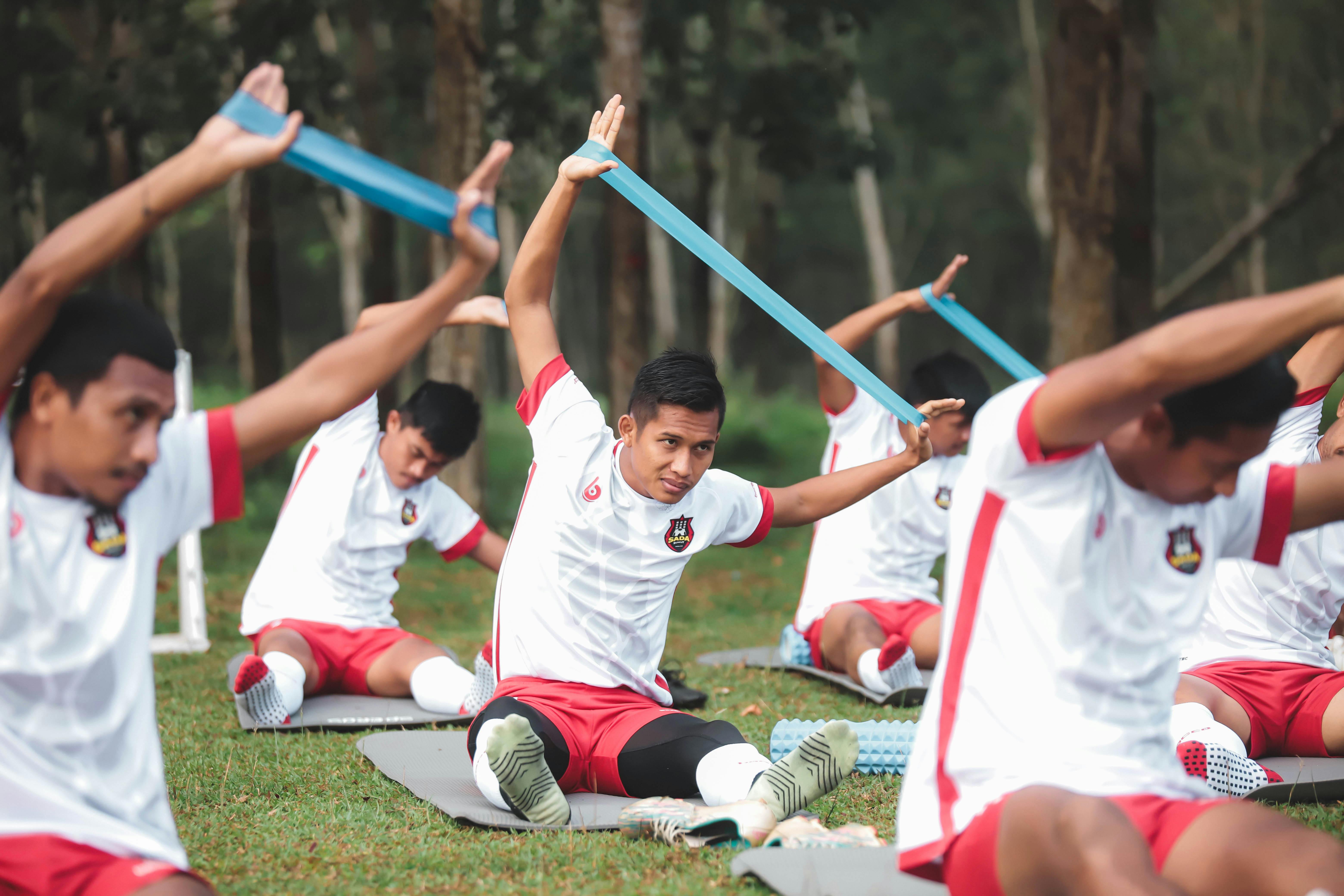 a group of men doing exercises in the grass