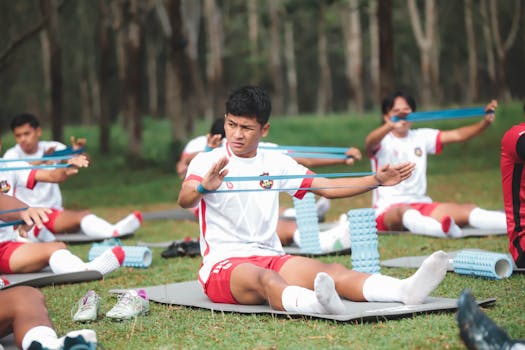 Group of young soccer players exercising with resistance bands outdoors in Jakarta, Indonesia.