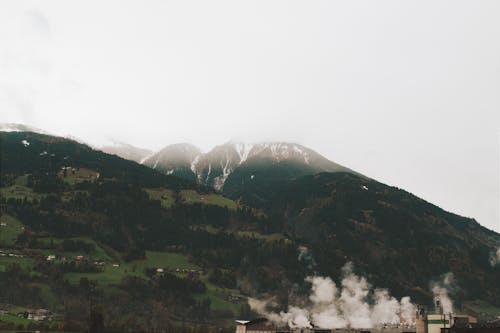 Free Smoke From the Village at the Foot of the Mountains Stock Photo