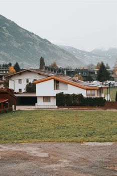 Experience the serene landscape of a Tyrolean village with modern architecture set against majestic mountains.