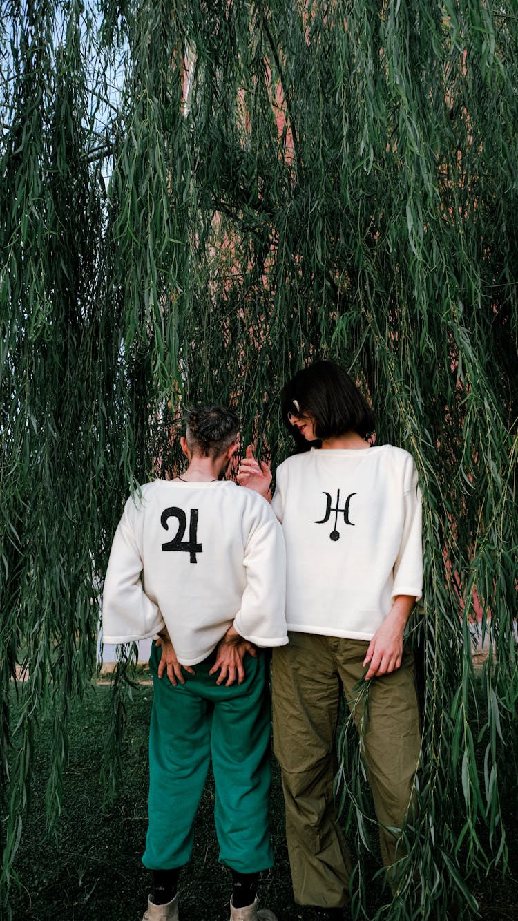 Models In Loose Fleece Printed Sweatshirts Under Willow Branches