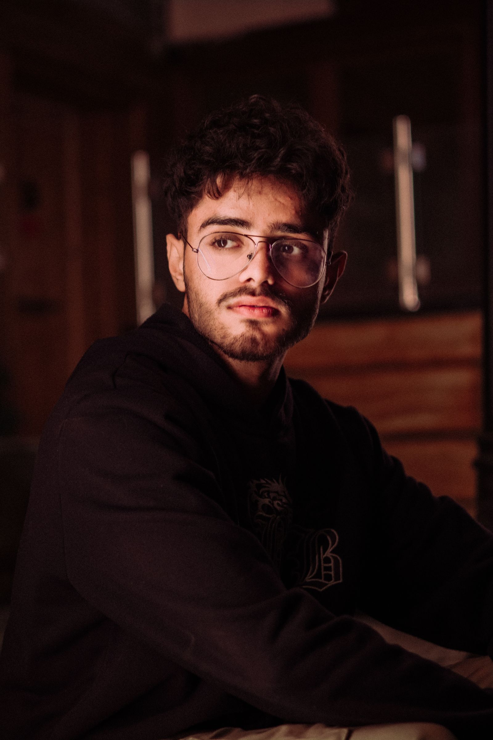 Man in round eyeglasses in a warm-lit room