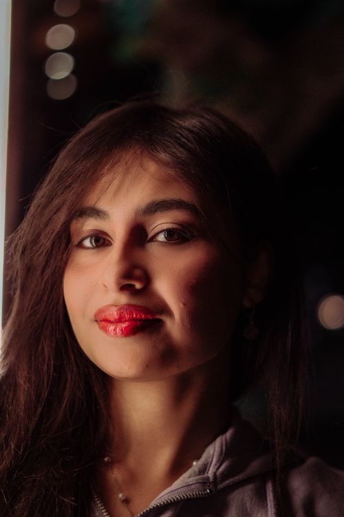 Free Intriguing portrait of a woman with striking red lipstick, captured with artistic lighting. Stock Photo