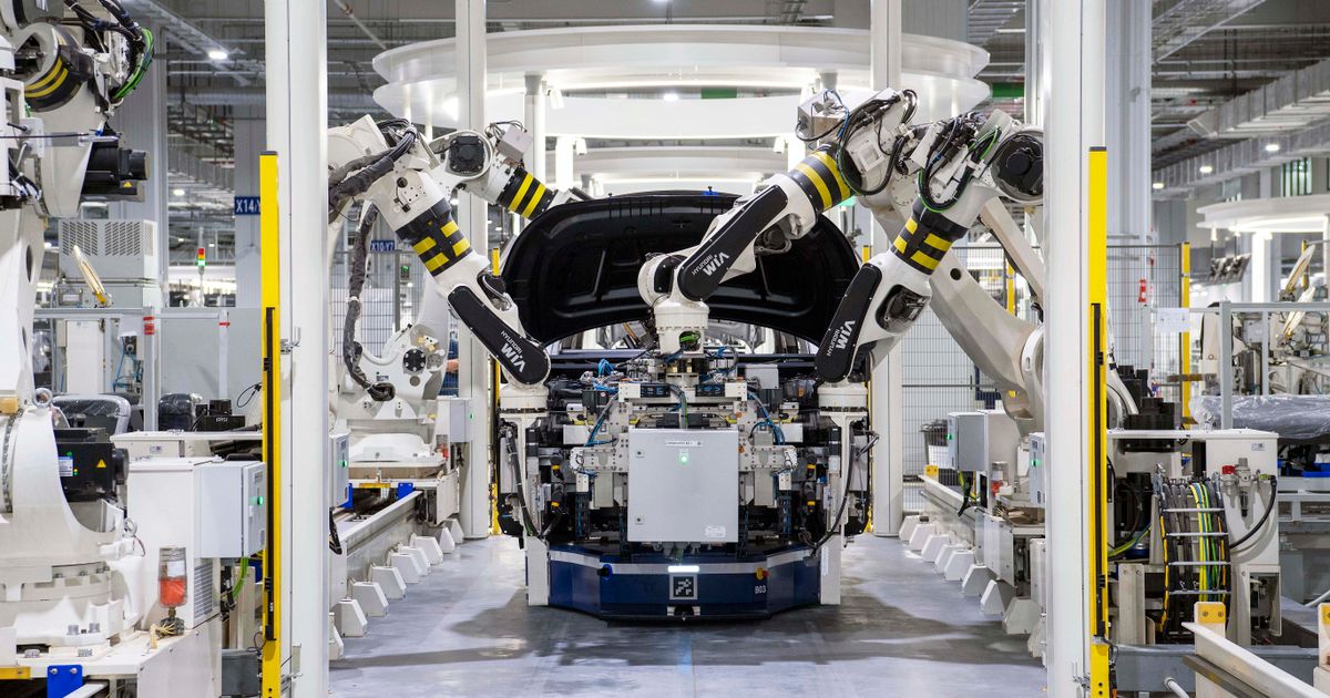 Robotic arms assembling a car on a modern factory line.