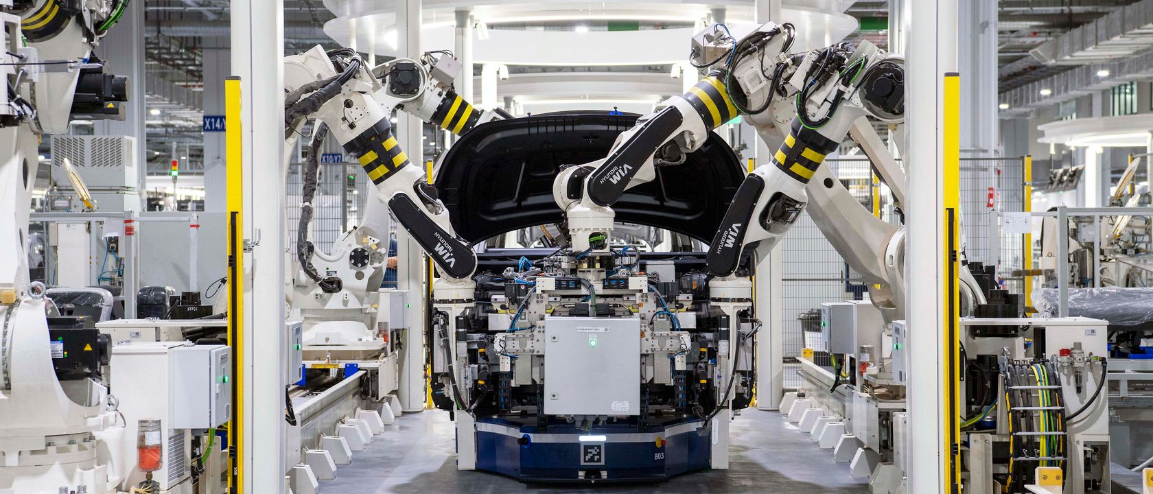 High-tech robots assembling a car in a modern factory setting, showcasing automation.