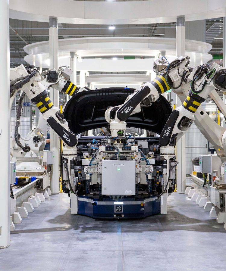 High-tech robots assembling a car in a modern factory setting, showcasing automation.