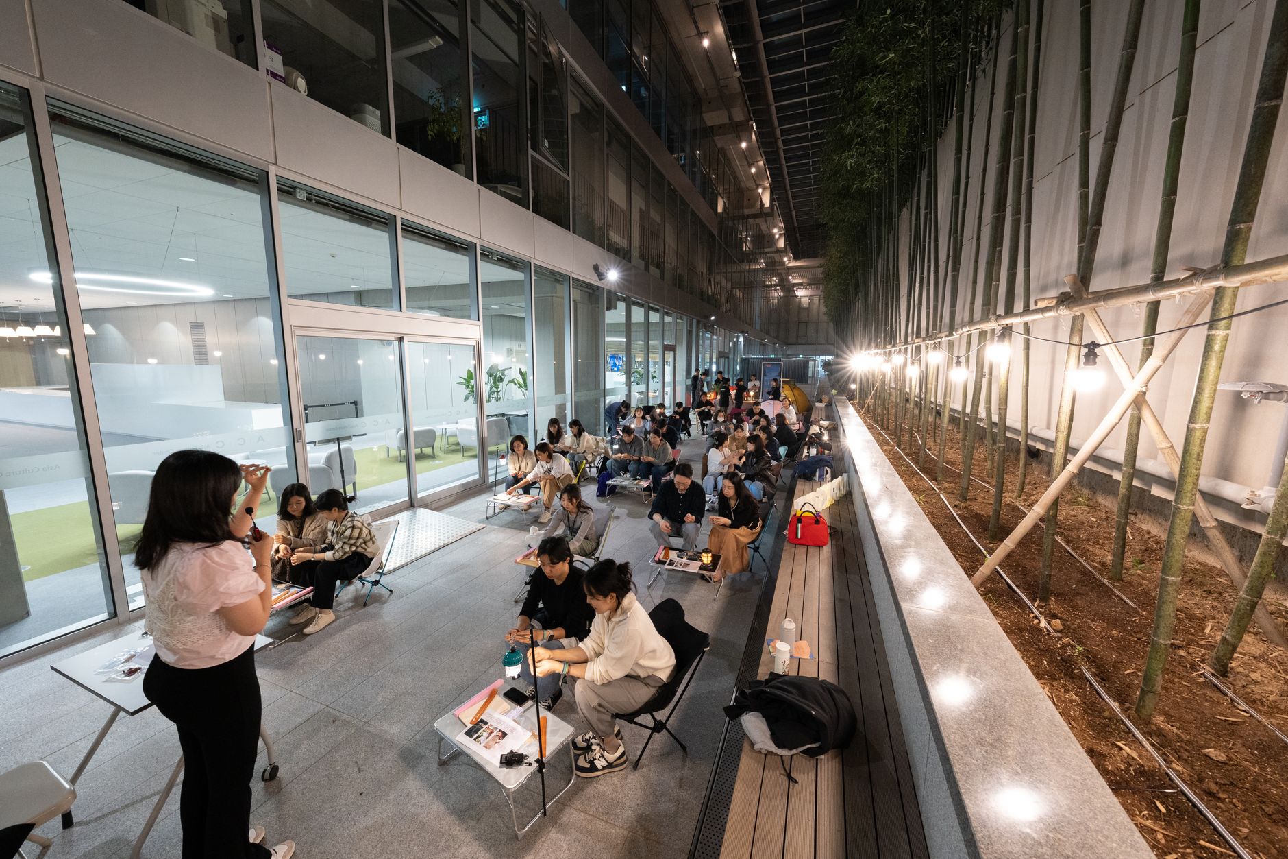 A nighttime educational workshop with instructor and engaged students in outdoor setting.