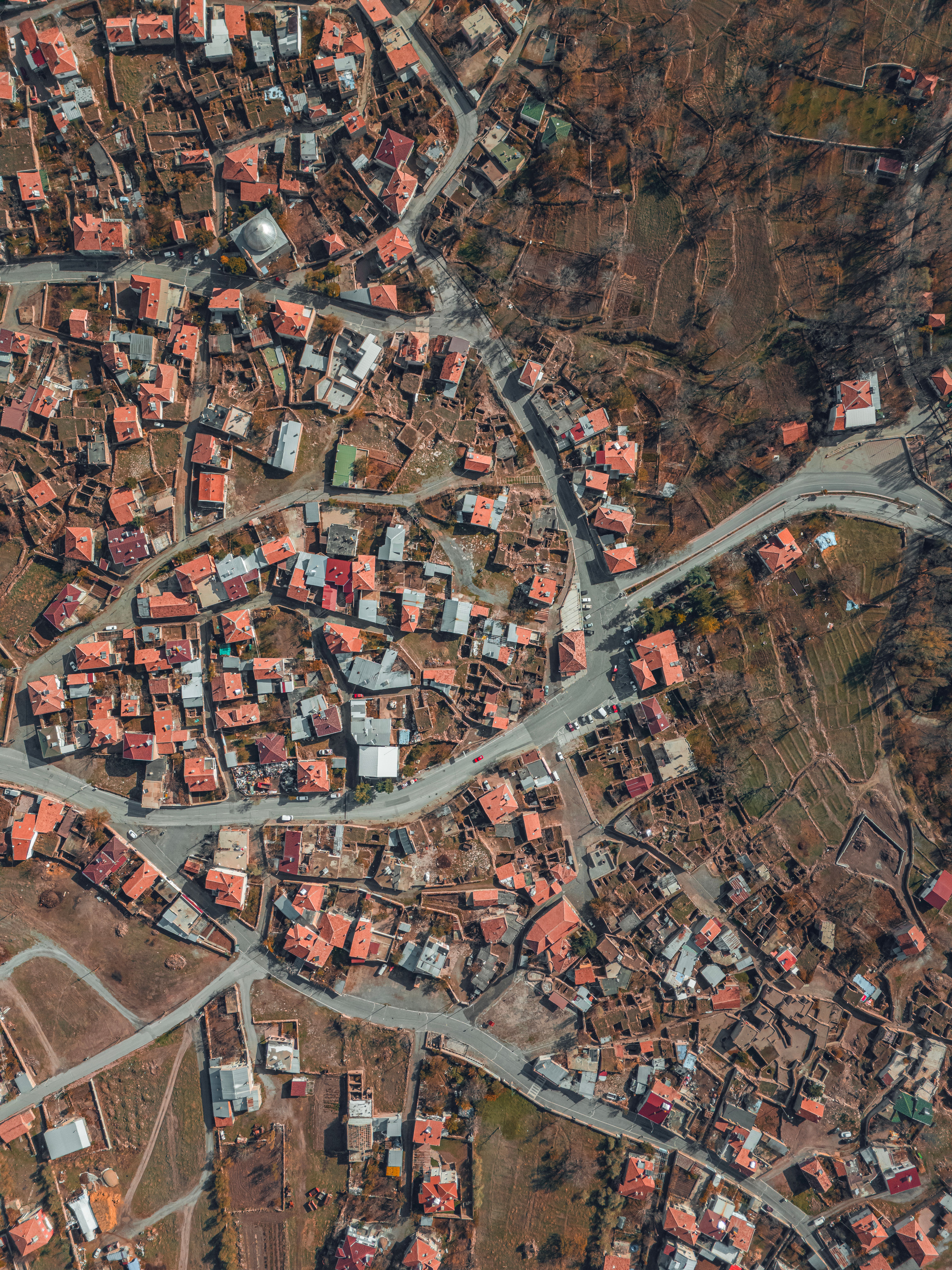 High-angle drone shot of town infrastructure with residential buildings and roads.