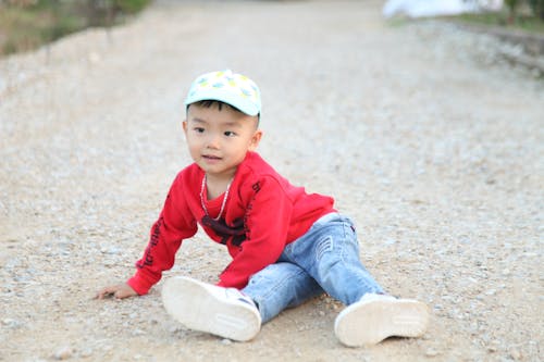 Free A Little Boy Sitting on the Ground  Stock Photo