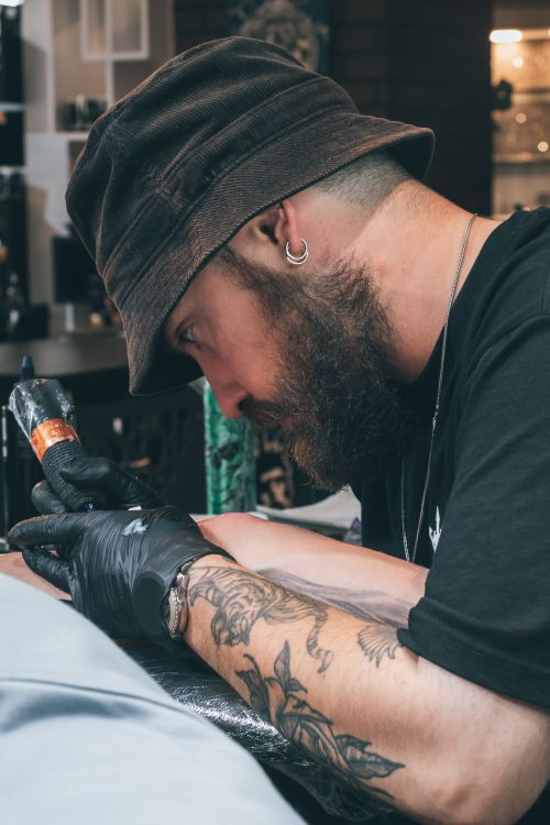 Free Tattoo artist focused while working on a design in a studio setting in Aydın, Türkiye. Stock Photo