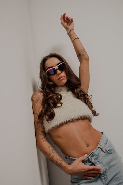 Young Woman with Tattoos Wearing a Trendy Outfit and Sunglasses 