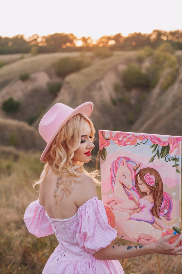 Blonde In Pink Dress Holding Painting