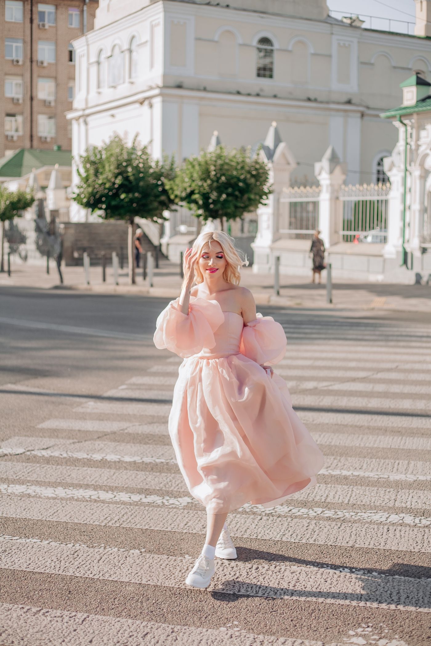 A woman in a pink strapless dress on a crosswalk — modern blush occasion styling