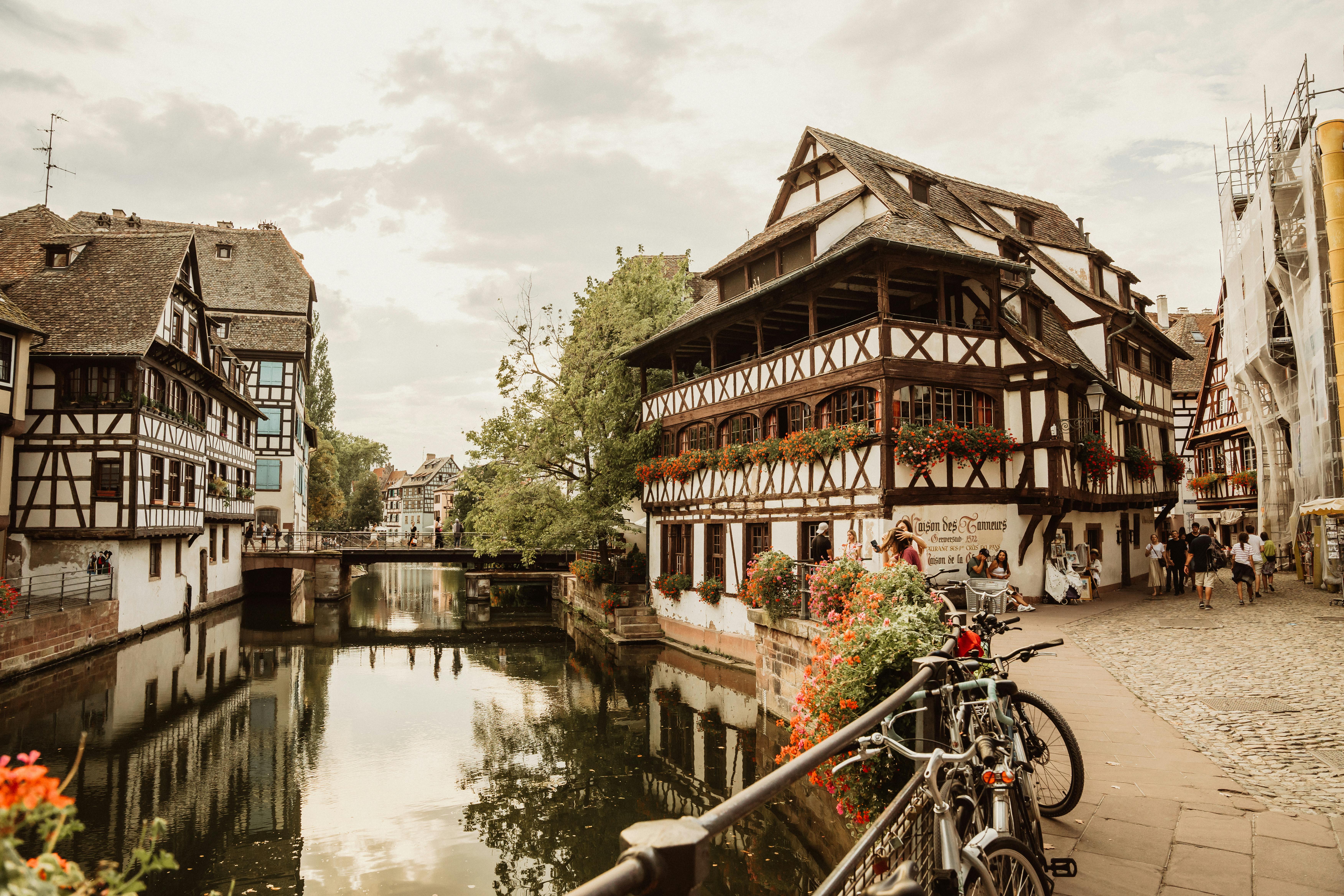 Picturesque view of Strasbourg's historic canal with charming half-timbered houses and cobblestone paths.