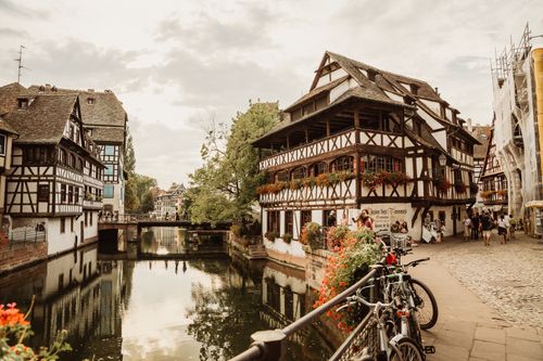 Free Picturesque view of Strasbourg's historic canal with charming half-timbered houses and cobblestone paths. Stock Photo