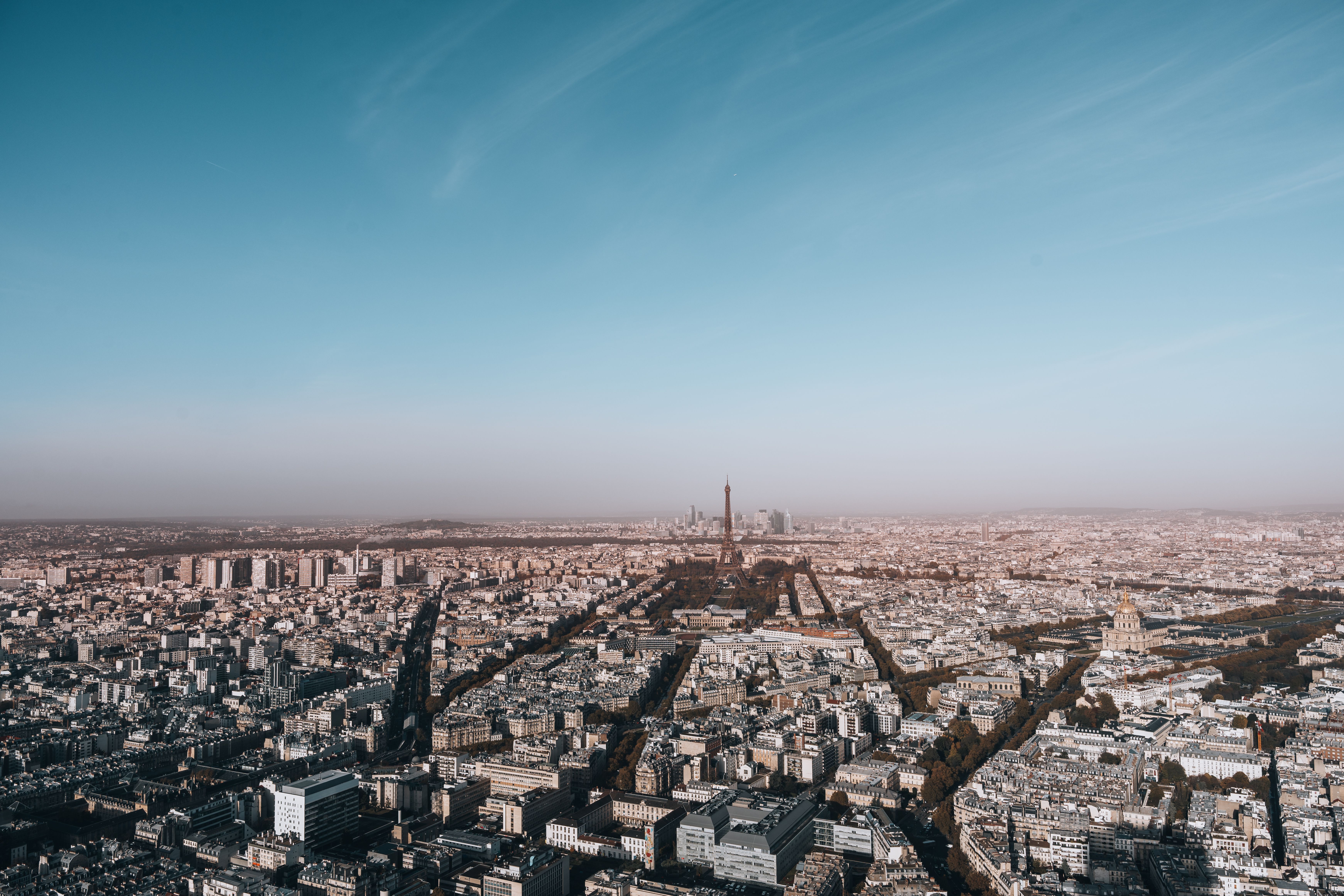 Breathtaking aerial view of Paris highlighting the iconic Eiffel Tower under a clear blue sky.