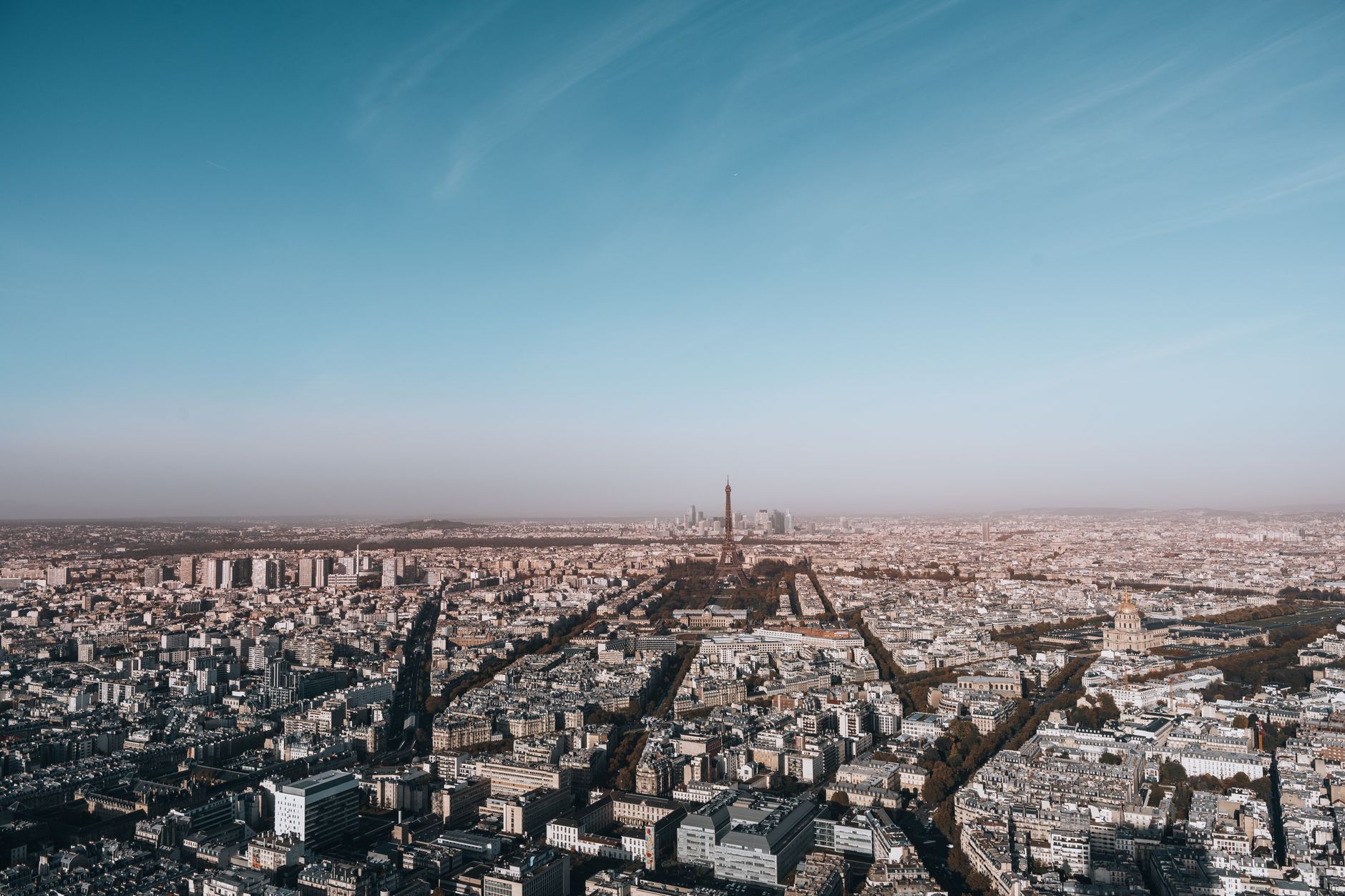 Breathtaking aerial view of Paris highlighting the iconic Eiffel Tower under a clear blue sky.