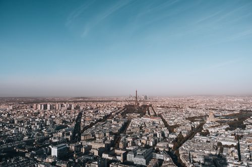 Free Breathtaking aerial view of Paris highlighting the iconic Eiffel Tower under a clear blue sky. Stock Photo