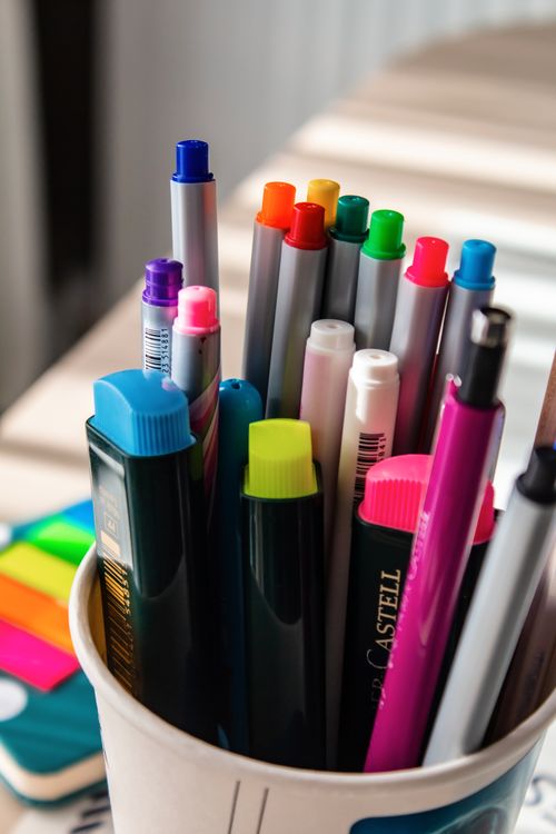 Free Close-up of a cup filled with vibrant pens and markers on a desk. Stock Photo