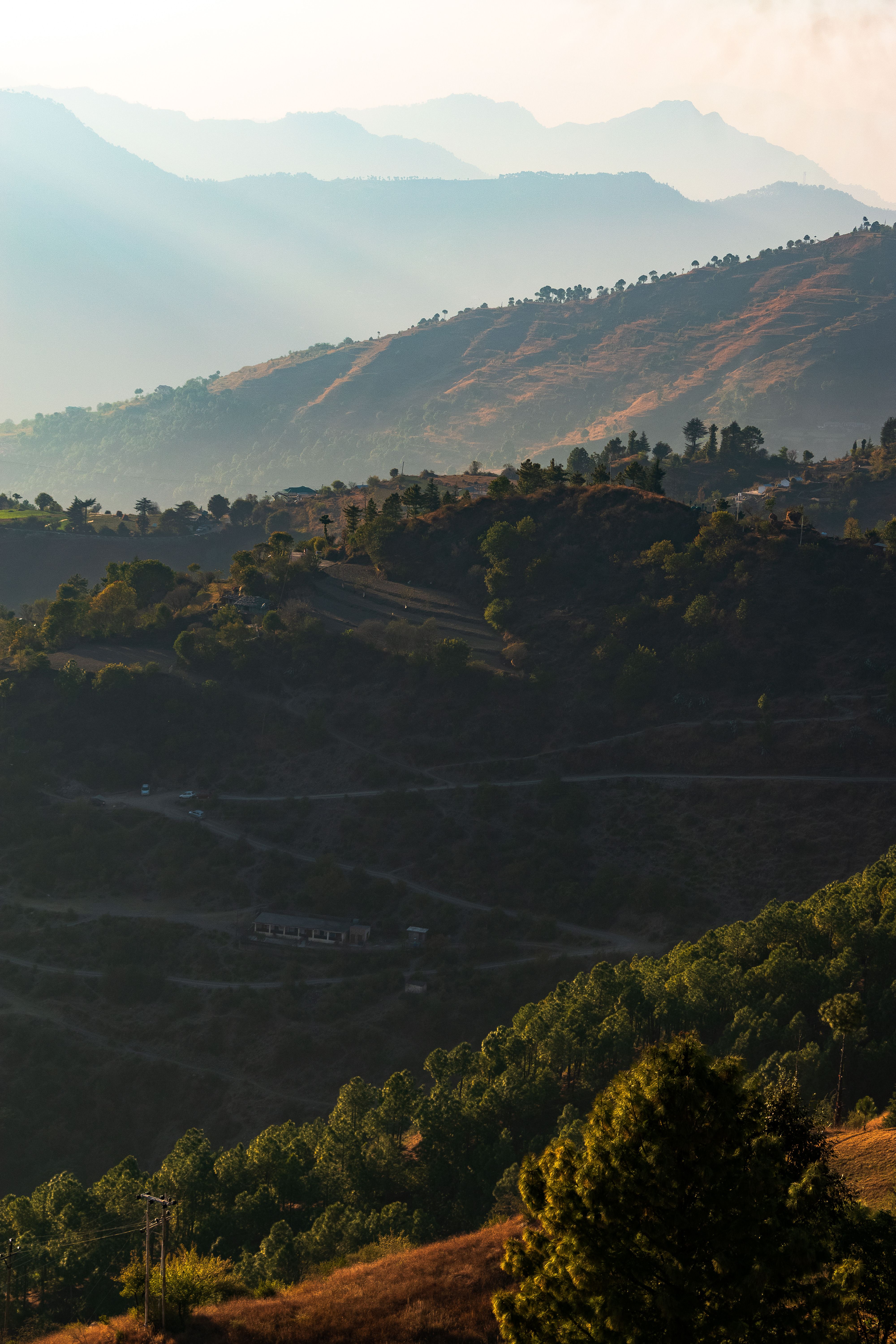 A breathtaking view of rolling hills and mountains at sunrise. Ideal for nature enthusiasts.